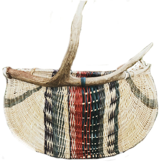 This unique basket showcases an artistic blend of colors, including rich reds and blues, beautifully woven into a natural, textured design. The addition of a driftwood or antler handle offers a rustic charm, enhancing its distinctive appeal. This basket combines both functionality and artistry, making it suitable for storage or as a decorative piece. Ideal for those interested in basket kits and basket materials, this item exemplifies creativity in fiber art and basketry, making it a standout choice for any