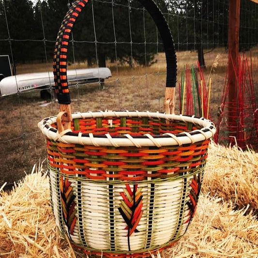 Woven basket with colorful design on a pile of hay